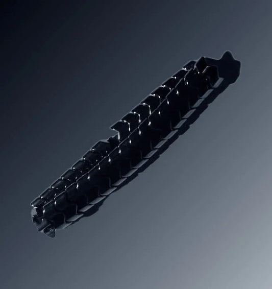 Glossy black hair clip with a geometric pattern on a dark gradient background, Éclat accessory