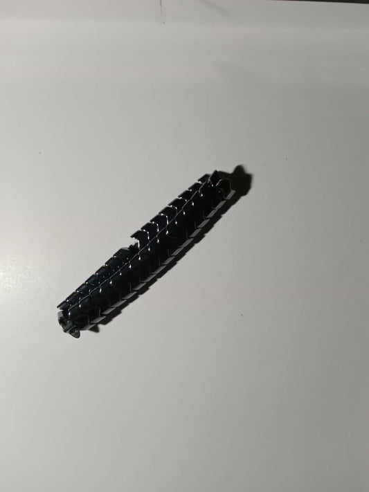 Close-up of a sleek black metallic latch on a white surface, modern minimal style.